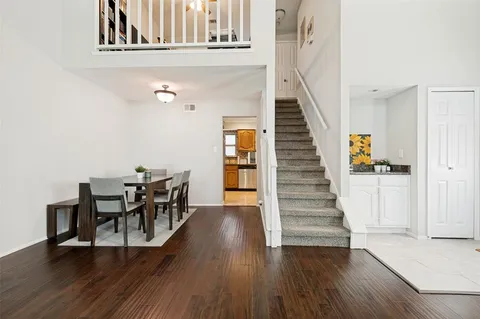 a view of a dining room with wooden floor and stairs