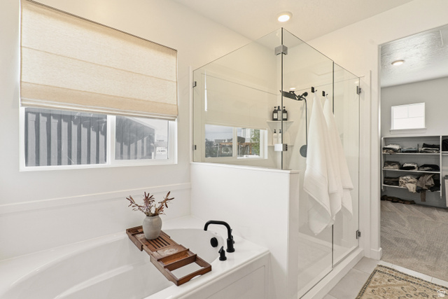870 North Ada Loop Lehi, UT 84048 - Photo 23 of 51 Built-in soaking tub with black fixtures, featuring a glass-enclosed shower with black hardware, recessed lighting, and a window with a Roman shade