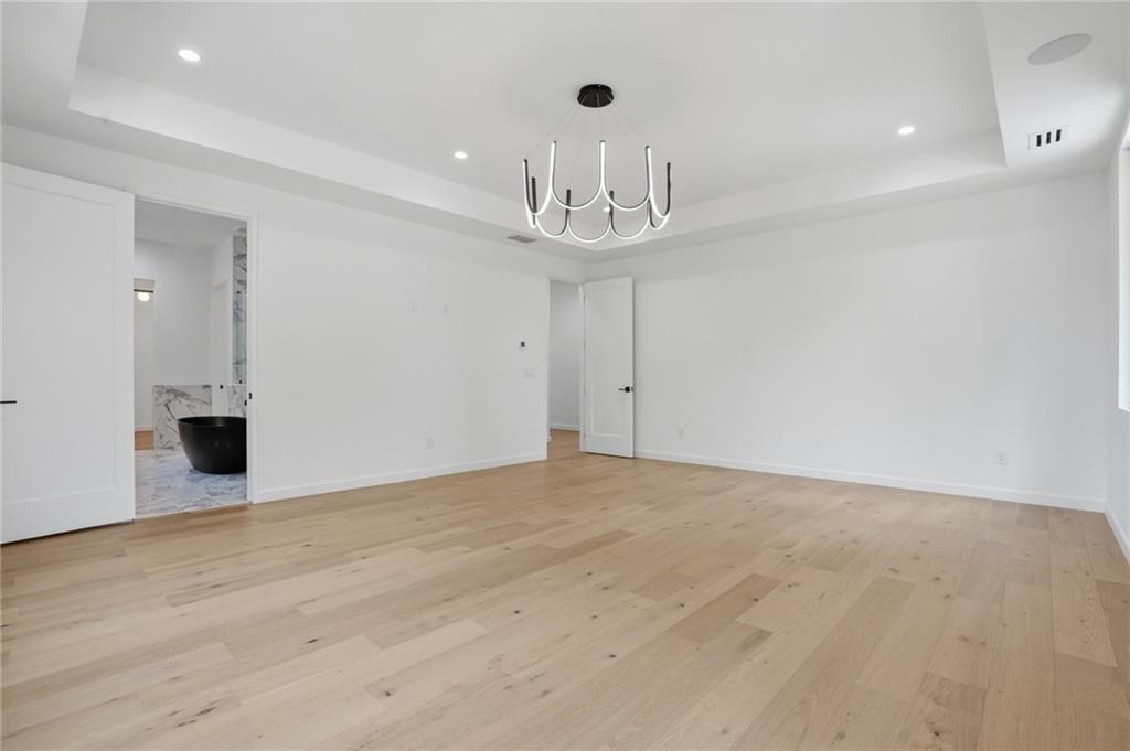 3293 Lenox Place Northeast Atlanta, GA 30324 - Photo 20 of 40 a view of an empty room with wooden floor and a chandelier