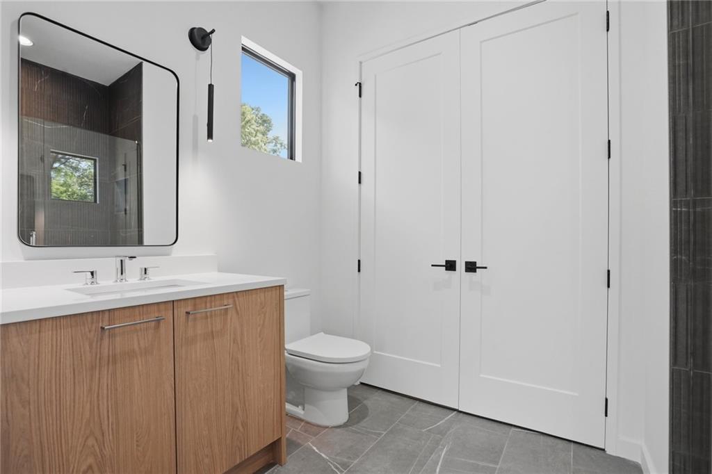 3293 Lenox Place Northeast Atlanta, GA 30324 - Photo 28 of 40 a bathroom with a toilet a sink and mirror