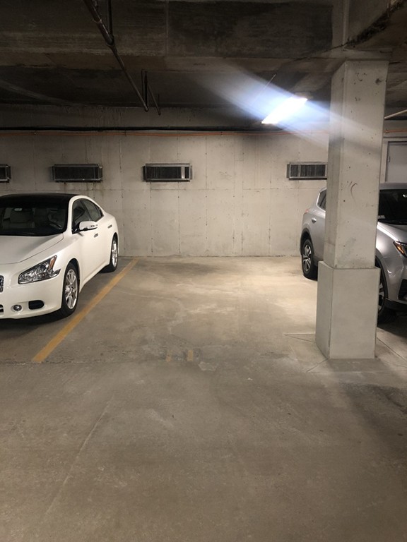 125 Pleasant Street, Unit 309 Brookline, MA 02446 - Photo 7 of 9 a view of parking garage with cars parked
