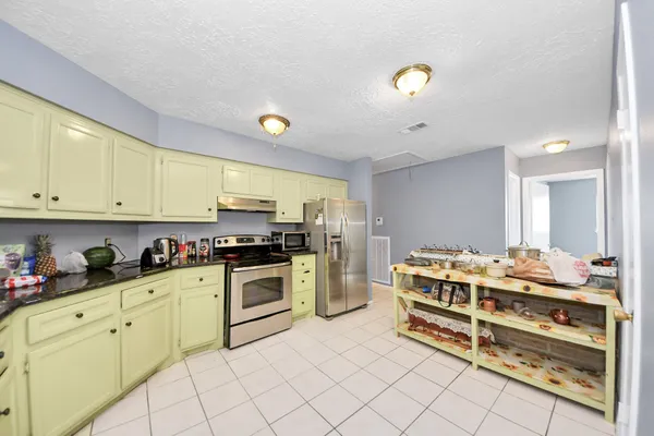 a kitchen with a stove a sink and cabinets