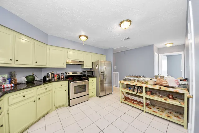 a kitchen with a stove a sink and cabinets
