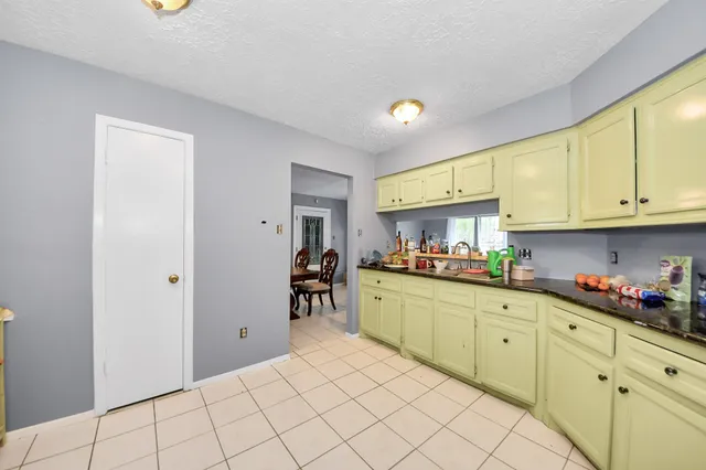 a kitchen with granite countertop a sink cabinets and stainless steel appliances