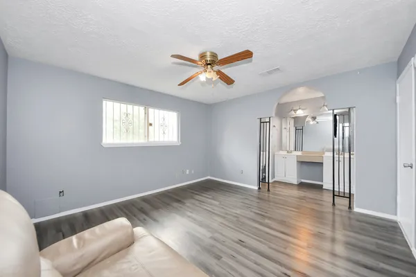 a view of a big room with wooden floor and a ceiling fan