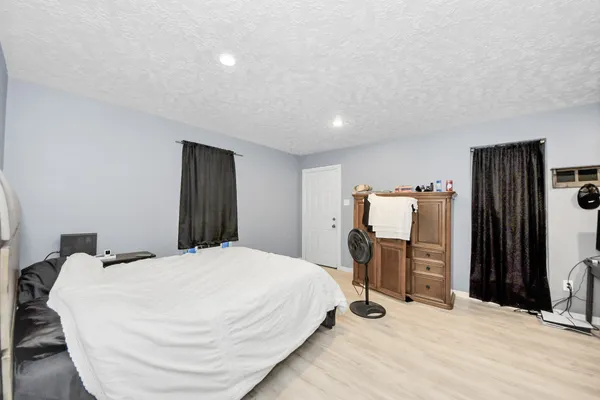 a bedroom with a bed and a refrigerator