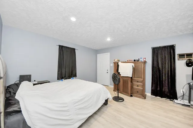 a bedroom with a bed and a refrigerator