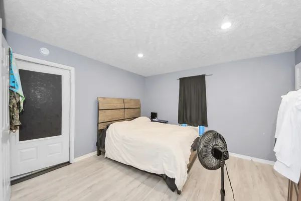 a bedroom with a bed and a painting on the wall