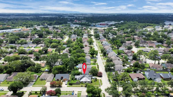 an aerial view of residential houses with outdoor space and trees
