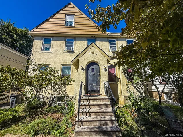 a view of a house with a yard and potted plants