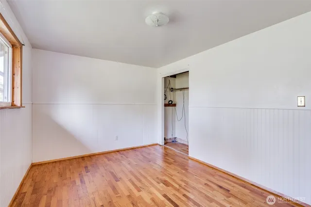 a view of empty room with wooden floor
