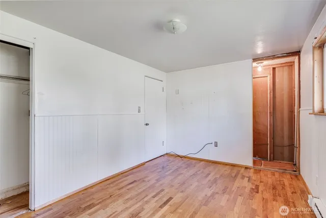 a view of empty room with wooden floor