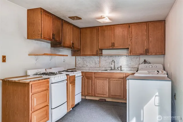 a kitchen with stainless steel appliances granite countertop a stove a sink dishwasher and a refrigerator