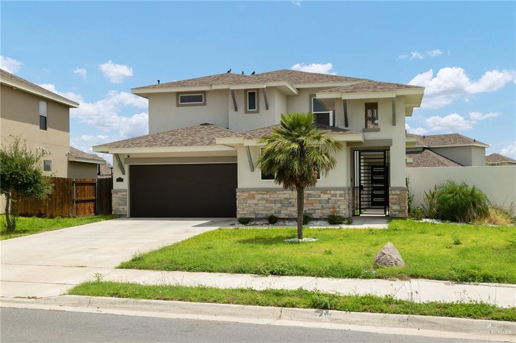a front view of a house with a yard and garage