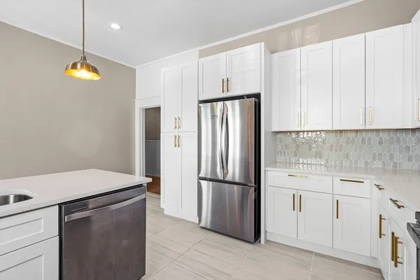 a kitchen with stainless steel appliances granite countertop a refrigerator a stove top oven a sink and dishwasher