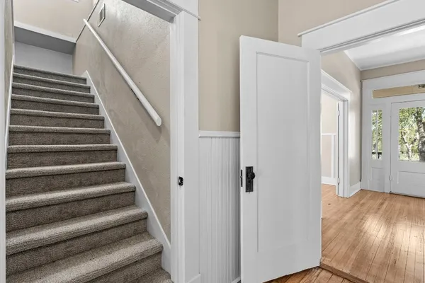 a view of a hallway with wooden floor and entryway