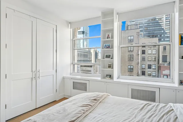 a bedroom with a bed and a large window