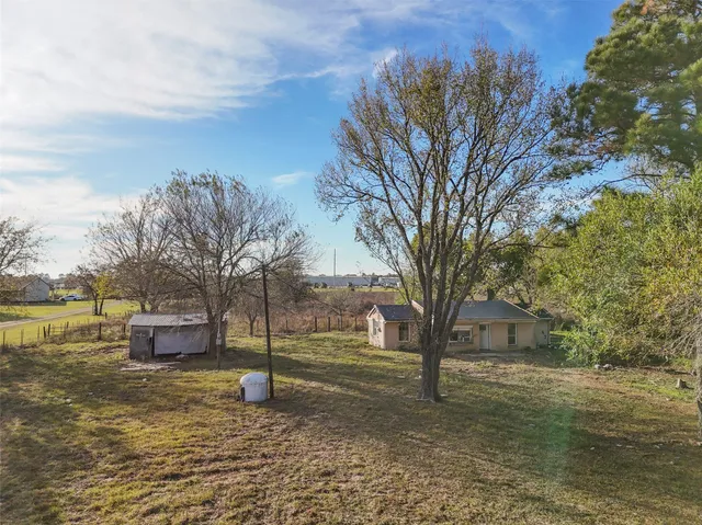 a view of a yard with large trees