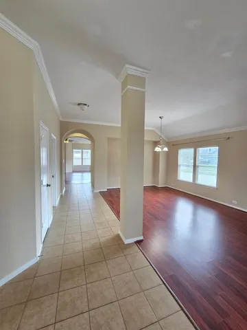 a view of a hallway with wooden floor and a living room