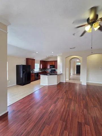 a living room with furniture and a wooden floor