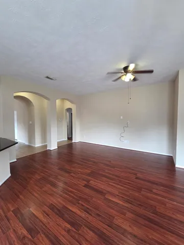 a view of a room with wooden floor and fan