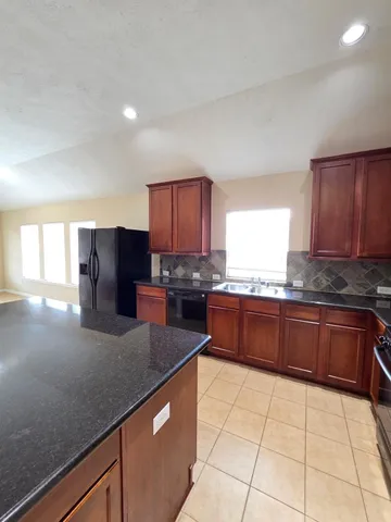 a kitchen with stainless steel appliances granite countertop a stove a sink a microwave and a refrigerator