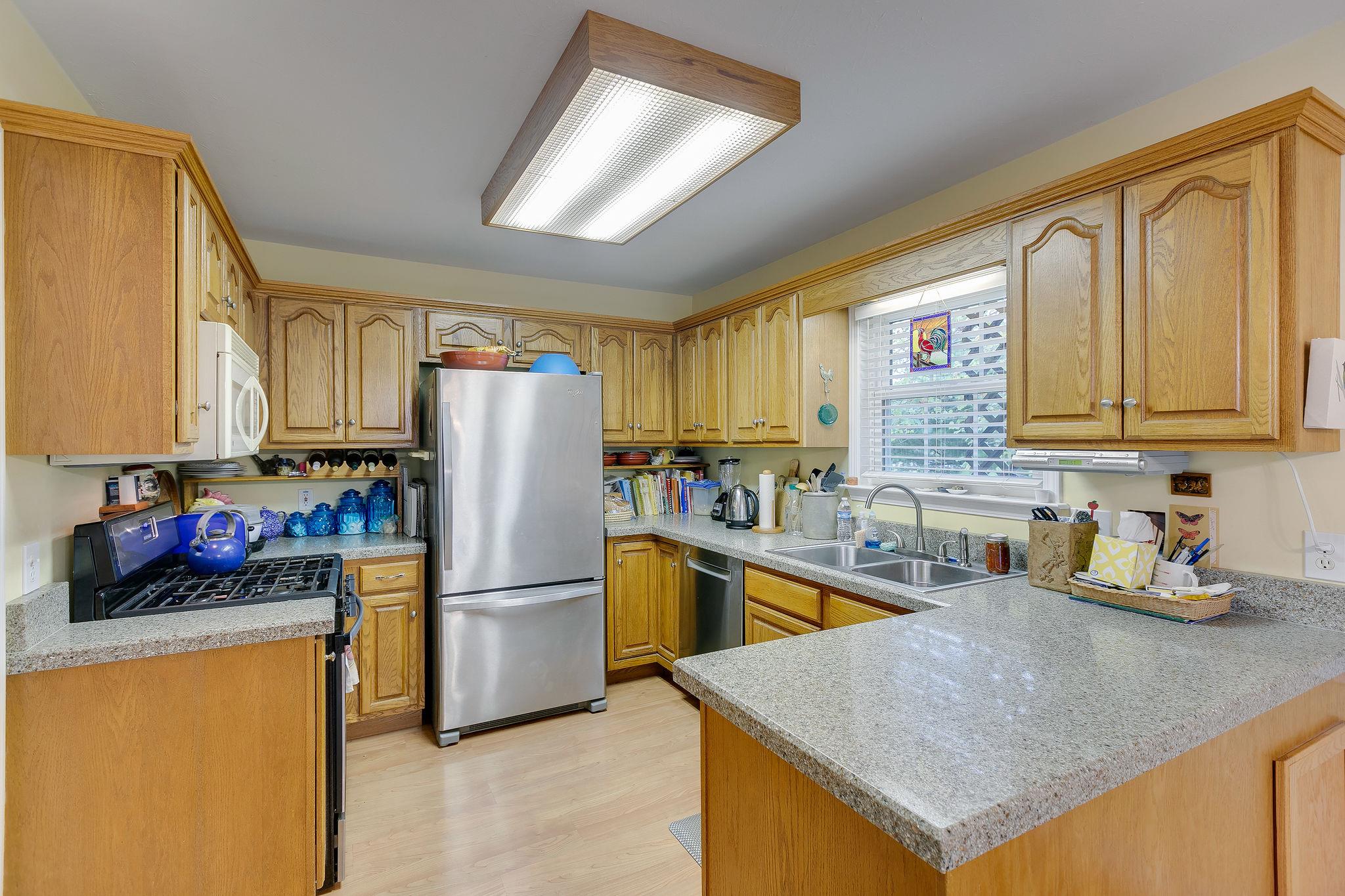 1900 Victorian Road Columbia, TN 38401 - Photo 8 of 24 a kitchen with stainless steel appliances granite countertop a refrigerator a sink dishwasher a stove with wooden cabinets and floor
