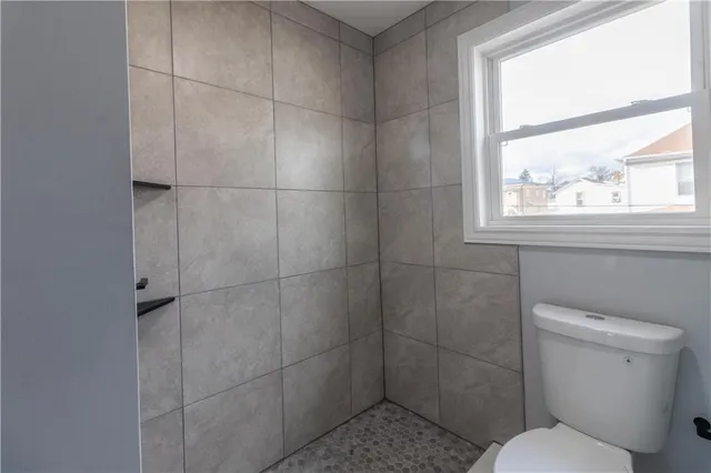 a bathroom with a toilet and a shower