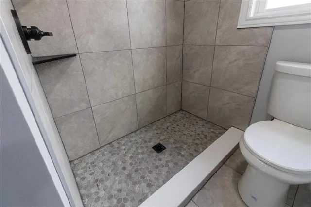 a bathroom with a granite countertop toilet and a sink