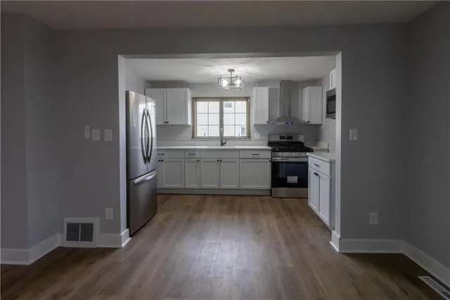 a kitchen with granite countertop stainless steel appliances and wooden cabinets