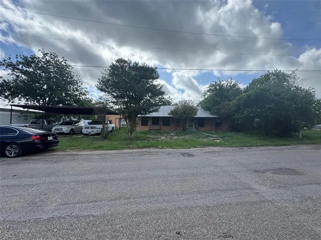 a view of a yard with car parked in front of it