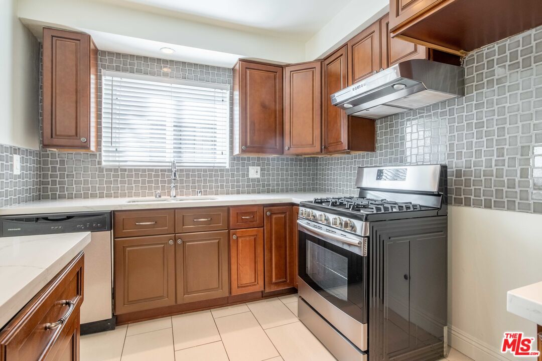 148 South Reeves Drive, Unit 4 Beverly Hills, CA 90212 - Photo 4 of 15 a kitchen with granite countertop a stove sink and cabinets