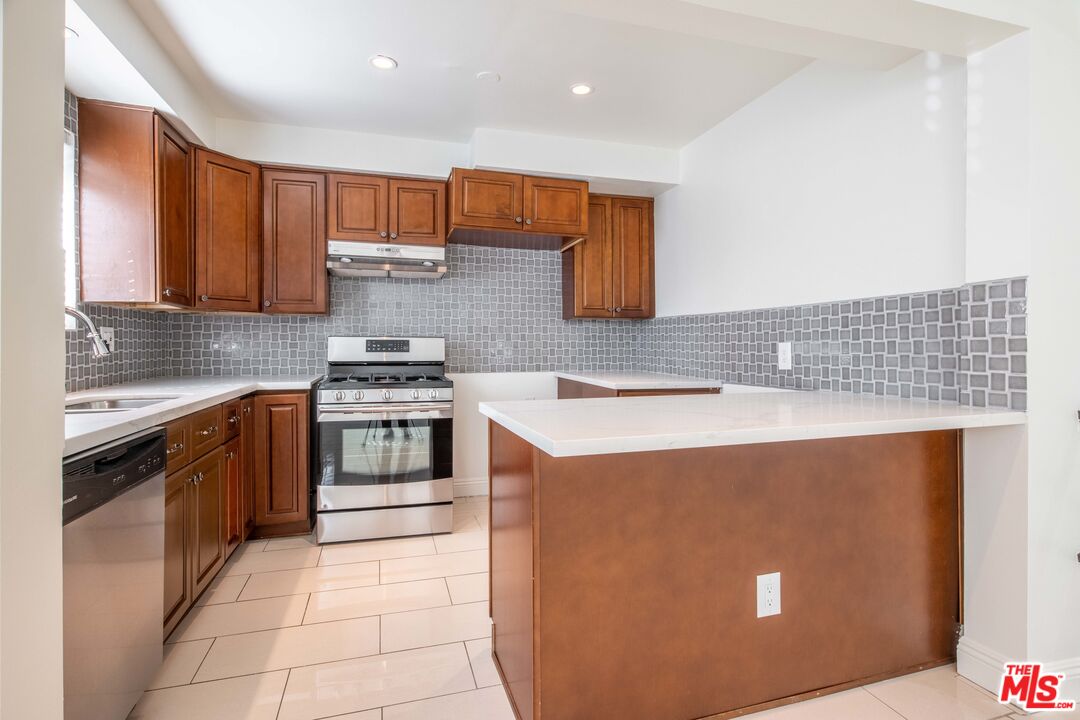 148 South Reeves Drive, Unit 4 Beverly Hills, CA 90212 - Photo 5 of 15 a kitchen with stainless steel appliances granite countertop a stove top oven