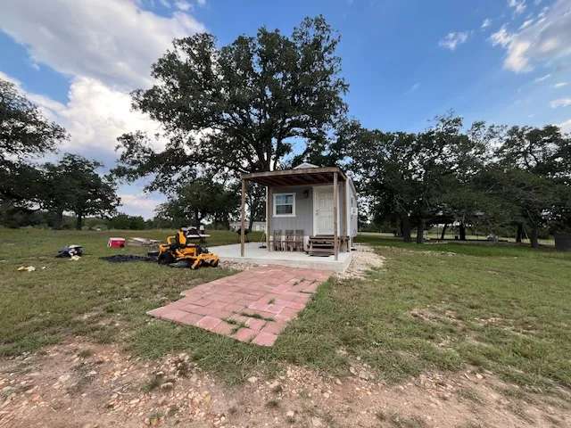 a view of a house with backyard and trees