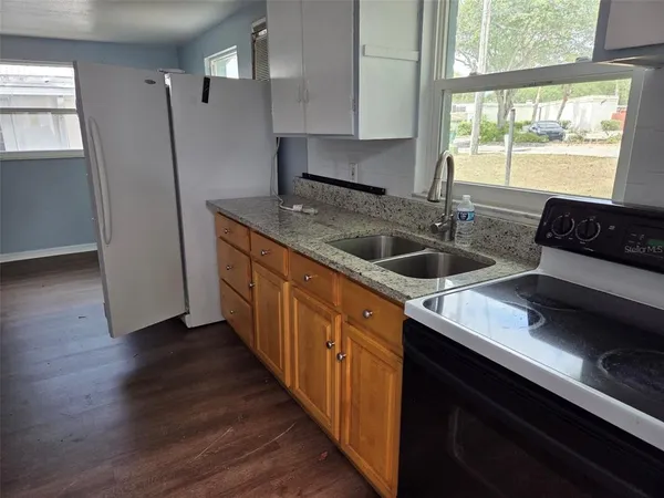 a kitchen with sink cabinets and wooden floor