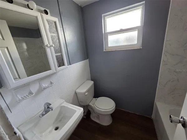 a white toilet sitting next to a bathroom sink