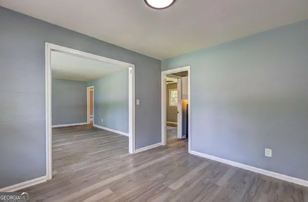 an empty room with wooden floor and closet