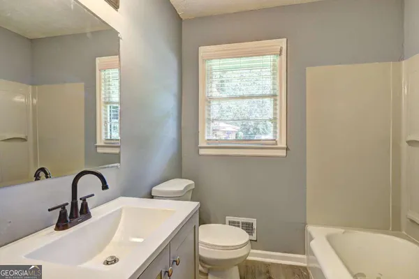 a bathroom with a toilet sink and mirror