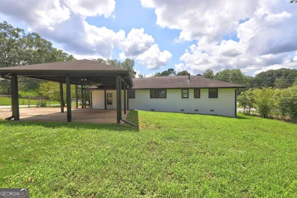 a view of a house with backyard and a tree