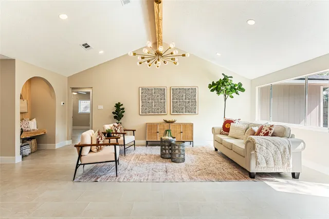 a living room with furniture and a chandelier