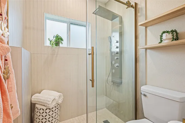 a bathroom with a toilet and a shower