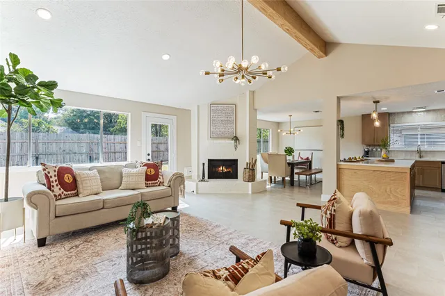 a living room with furniture a fireplace and a chandelier
