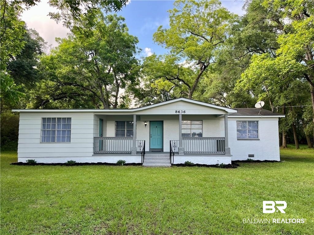 8636 Boe Road Irvington, AL 36544 - Photo 2 of 22 View of front of home featuring a porch, a front yard, and view of scattered trees