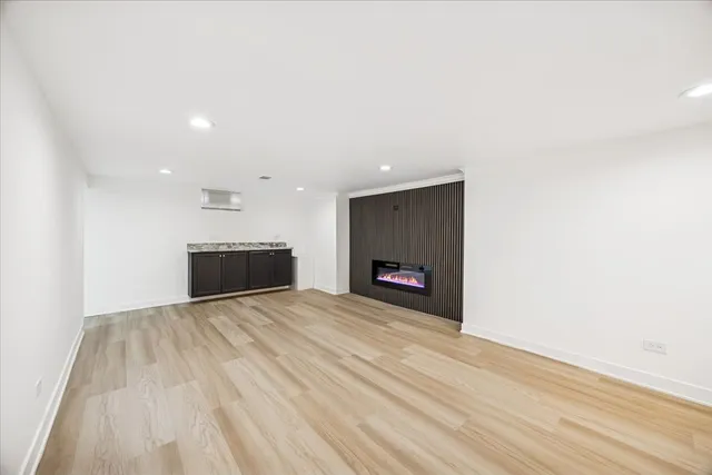 a view of empty room with wooden floor and fireplace