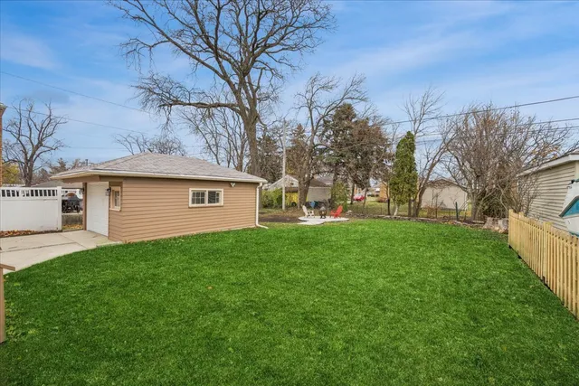 a view of a yard in front of a house with large tree