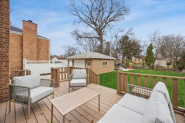 a view of a patio with couches table and chairs with wooden floor and fence