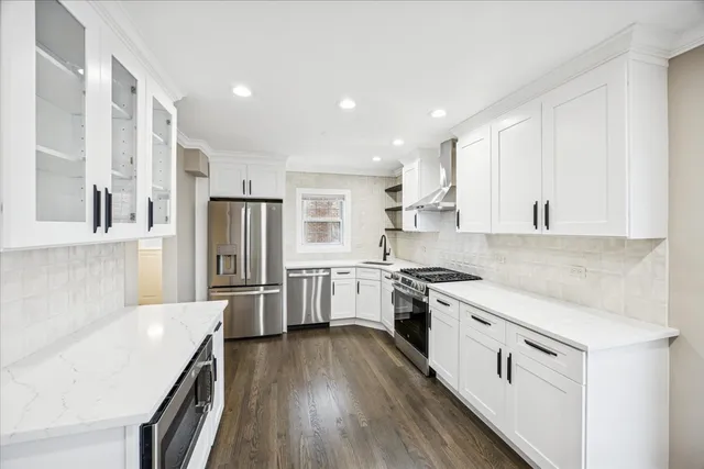 a large kitchen with stainless steel appliances granite countertop a lot of counter space and wooden floor