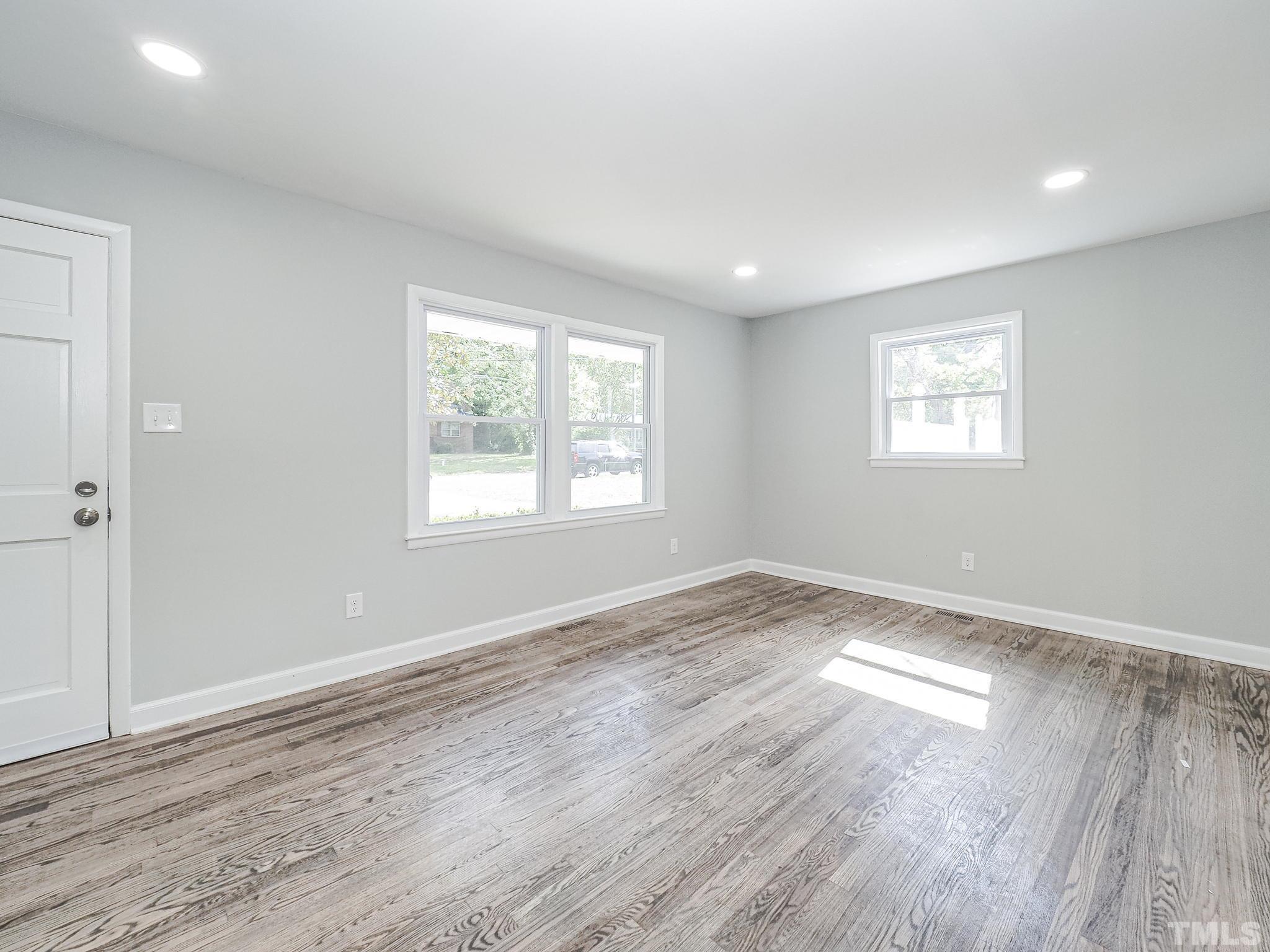 626 Winterlochen Road Raleigh, NC 27603 - Photo 2 of 16 an empty room with wooden floor and windows