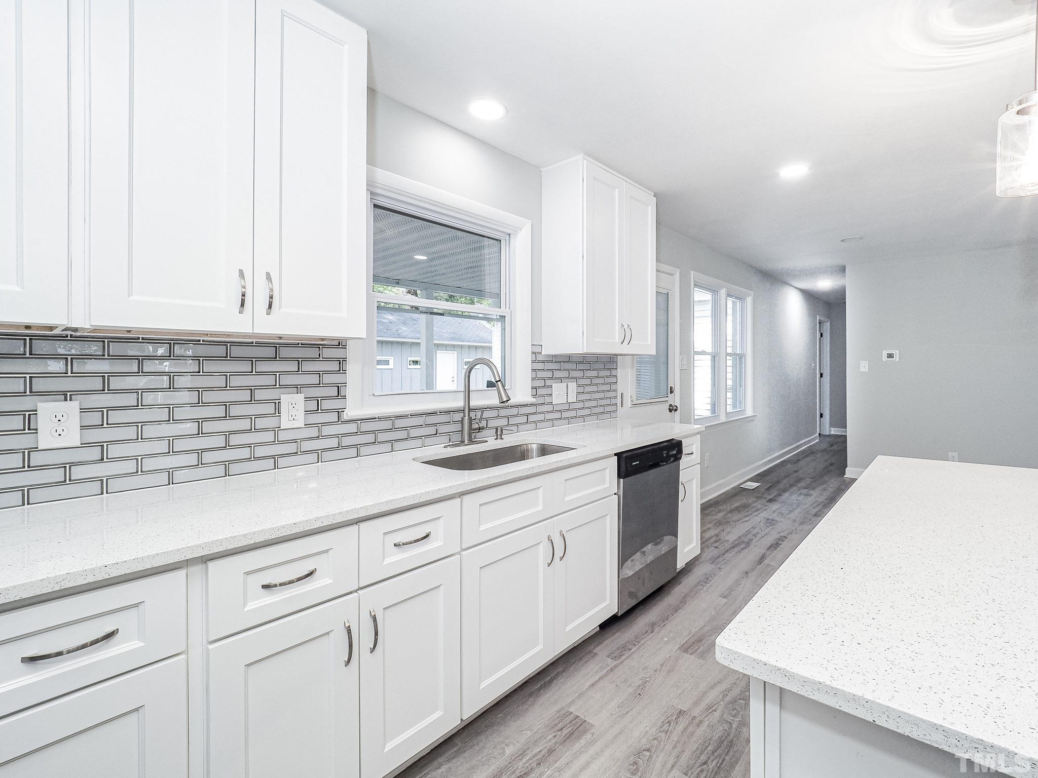 626 Winterlochen Road Raleigh, NC 27603 - Photo 3 of 16 a kitchen with granite countertop white cabinets and white appliances