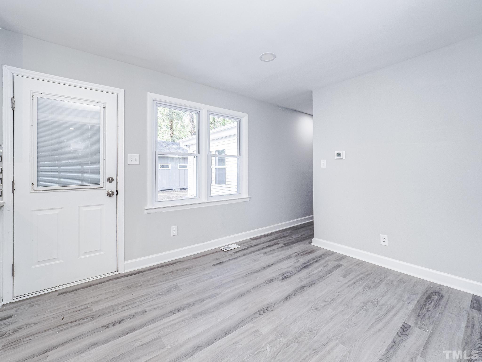 626 Winterlochen Road Raleigh, NC 27603 - Photo 5 of 16 a view of an empty room with wooden floor and a window